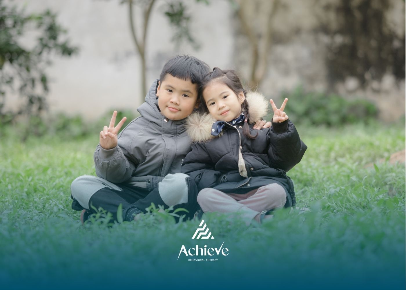 A child and an adult sit on a colorful floor. The child plays while the adult watches.