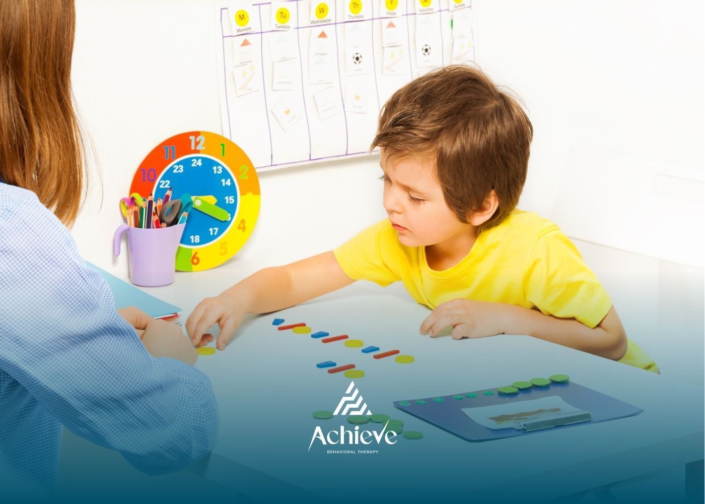 Child and adult at a table playing with colorful blocks; a colorful clock and pens visible.