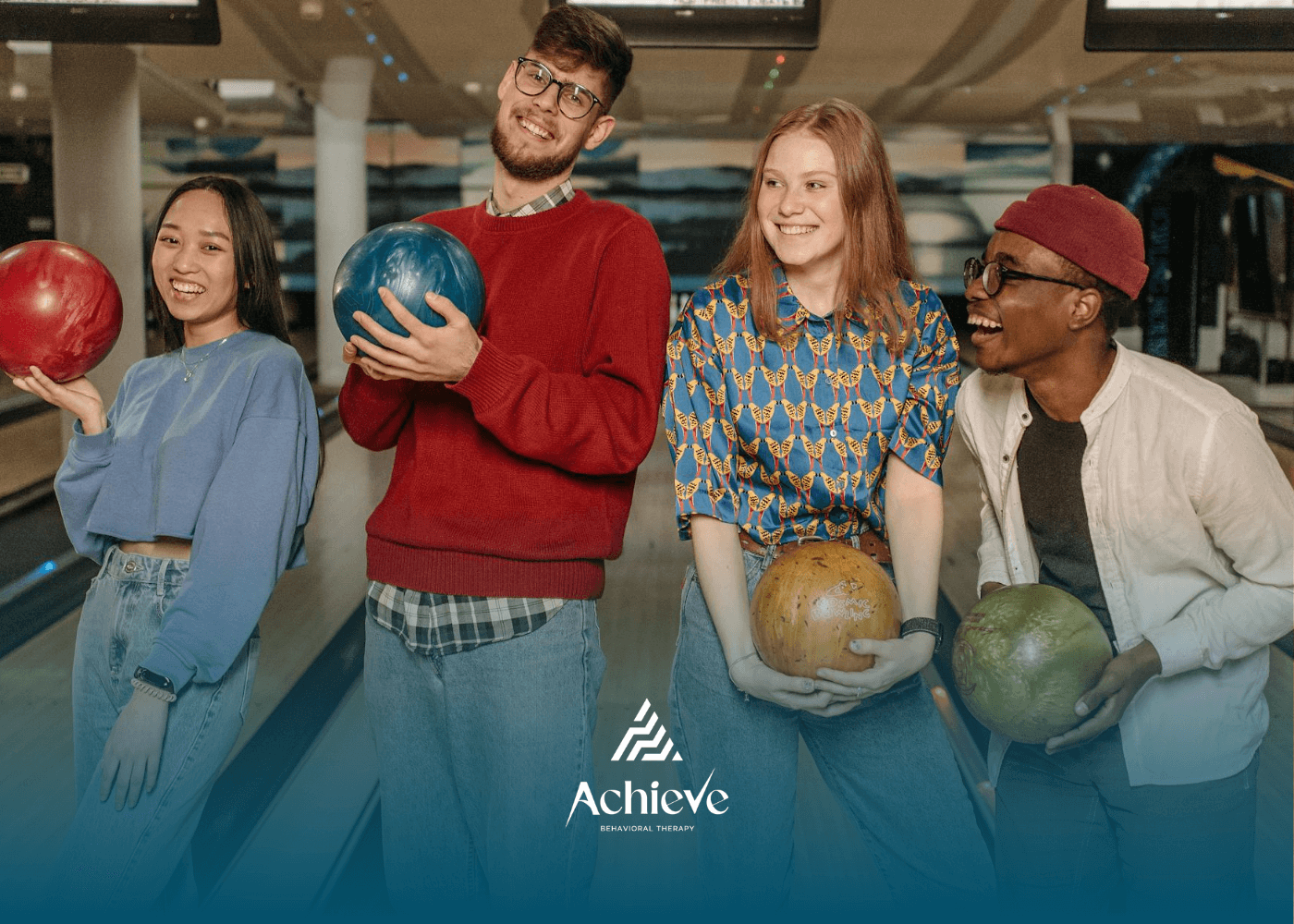 Four adults with autism holding bowling balls and smiling at alley during ABA therapy session in NJ.