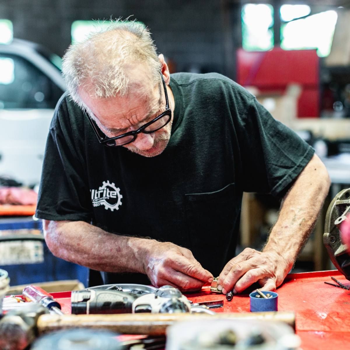 A man wearing glasses and a black shirt with the word n'tech on it