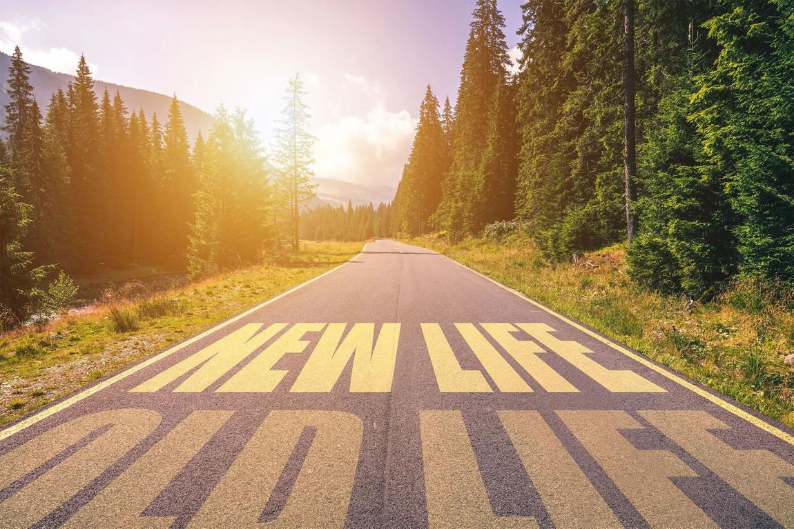 The word new life is painted on the side of a road.