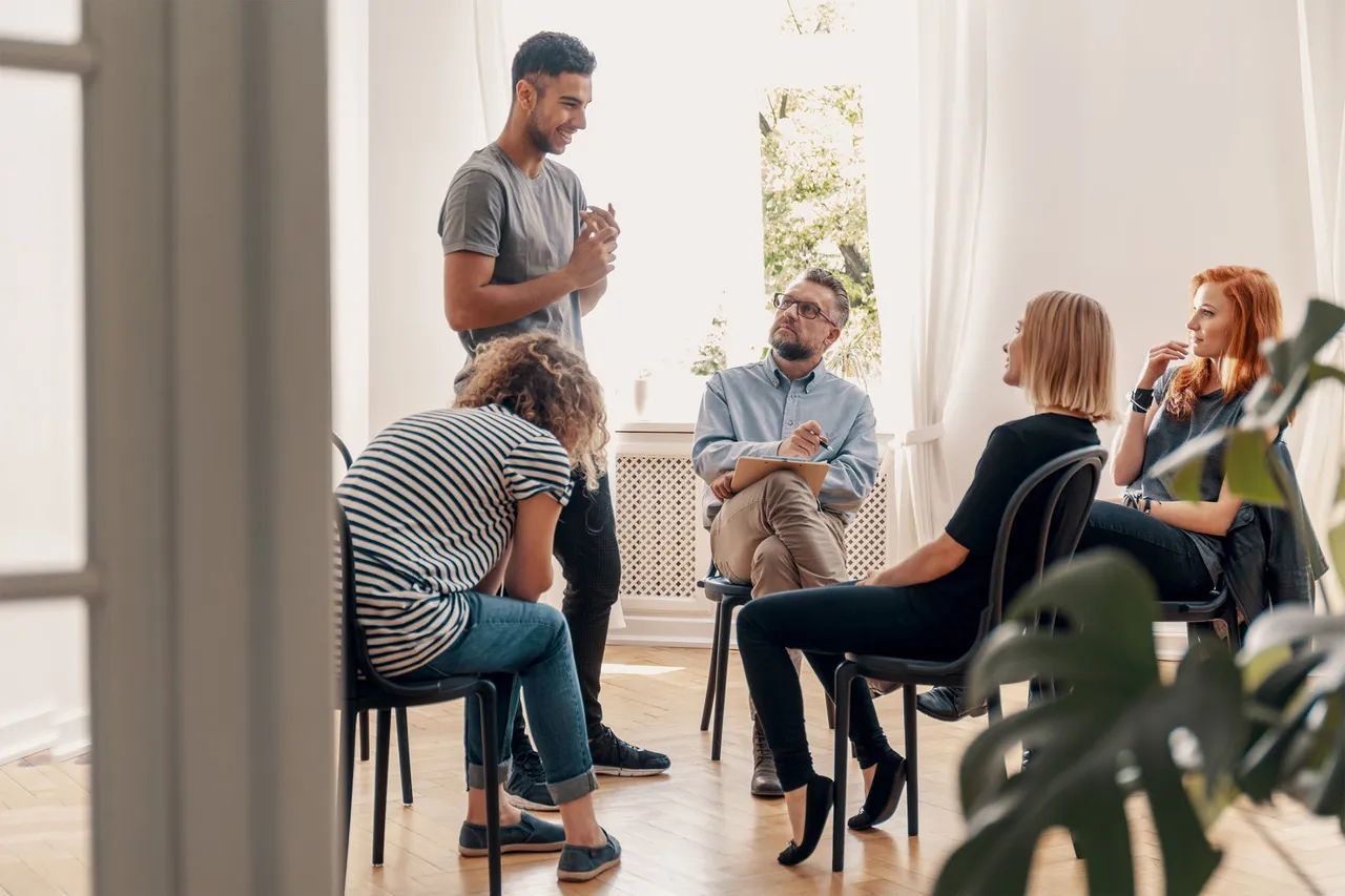 A group of people are sitting in a circle in a room.