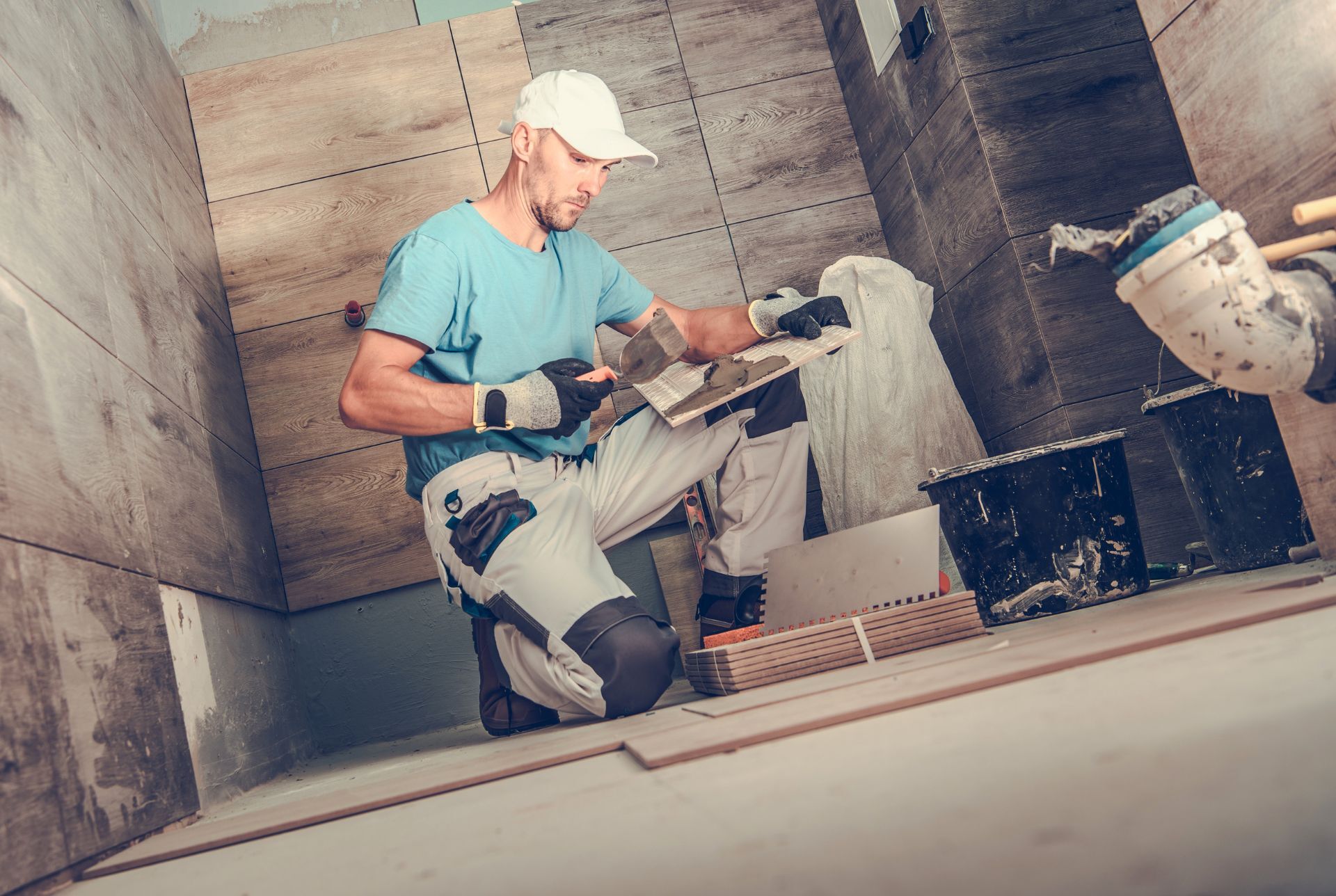 Bathroom installer laying tiles for a new floor in a brand new bathroom.