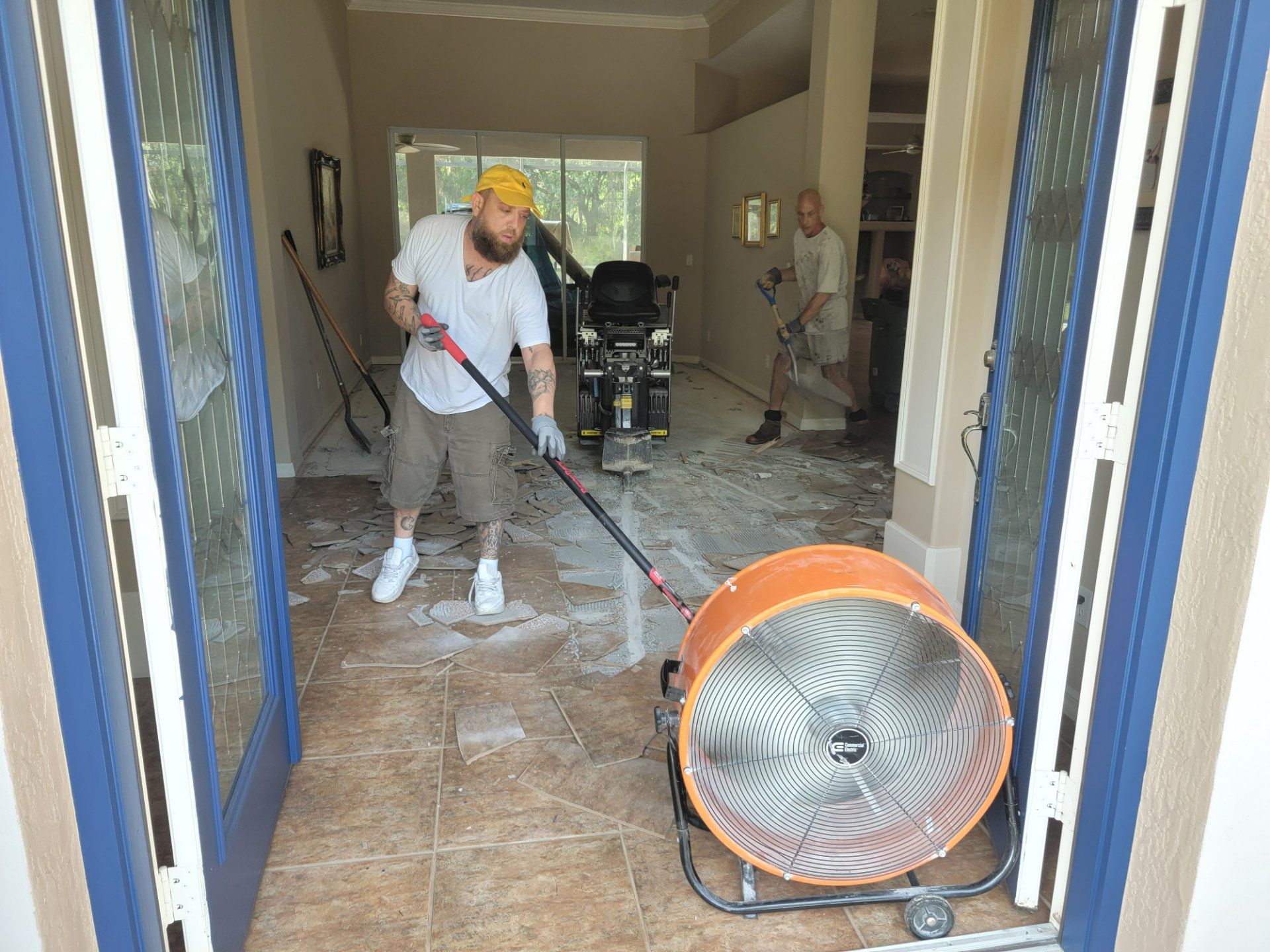A man is cleaning the floor of a house with a vacuum cleaner.