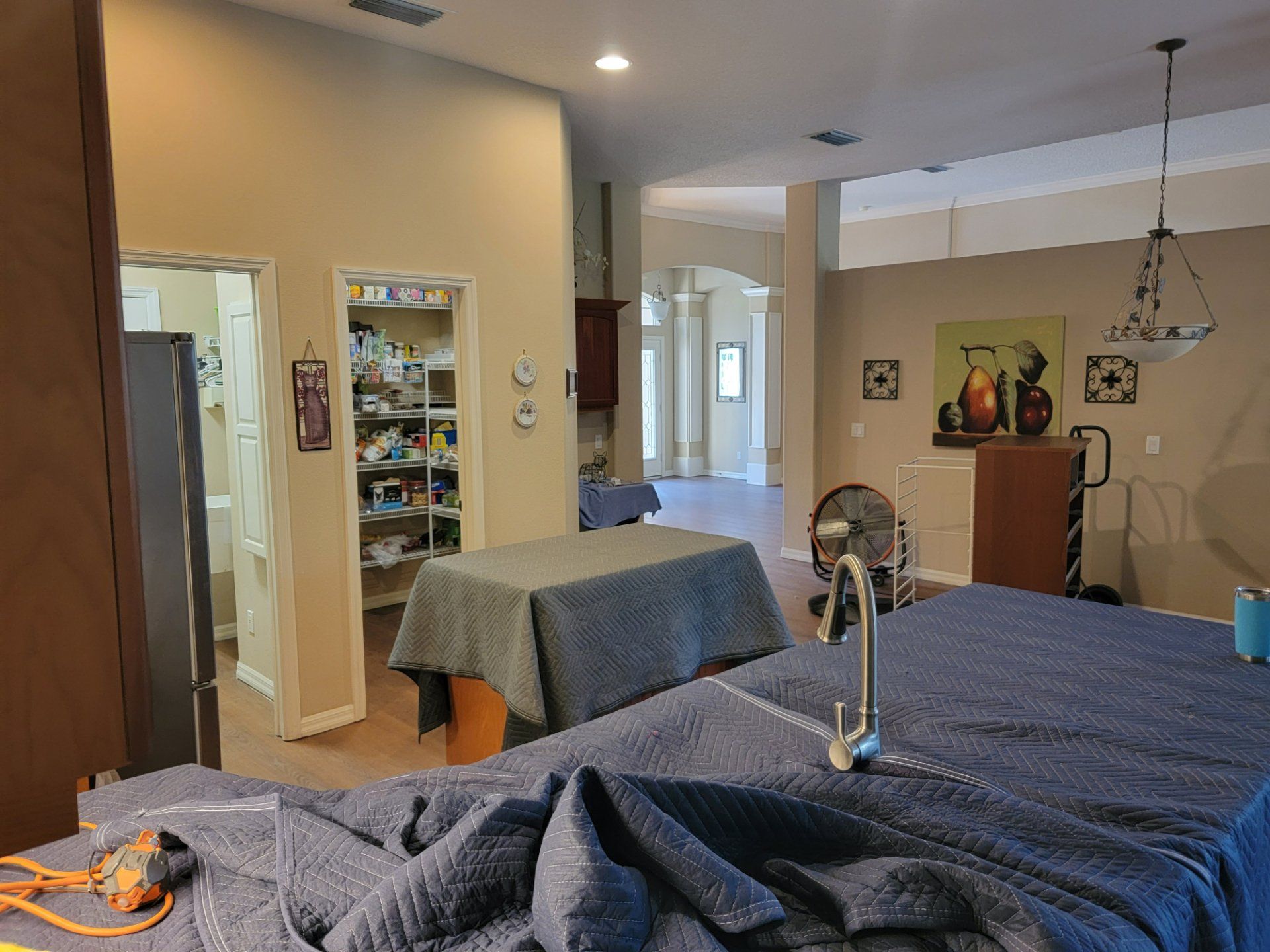 A kitchen with a sink and a table covered in blue blankets.