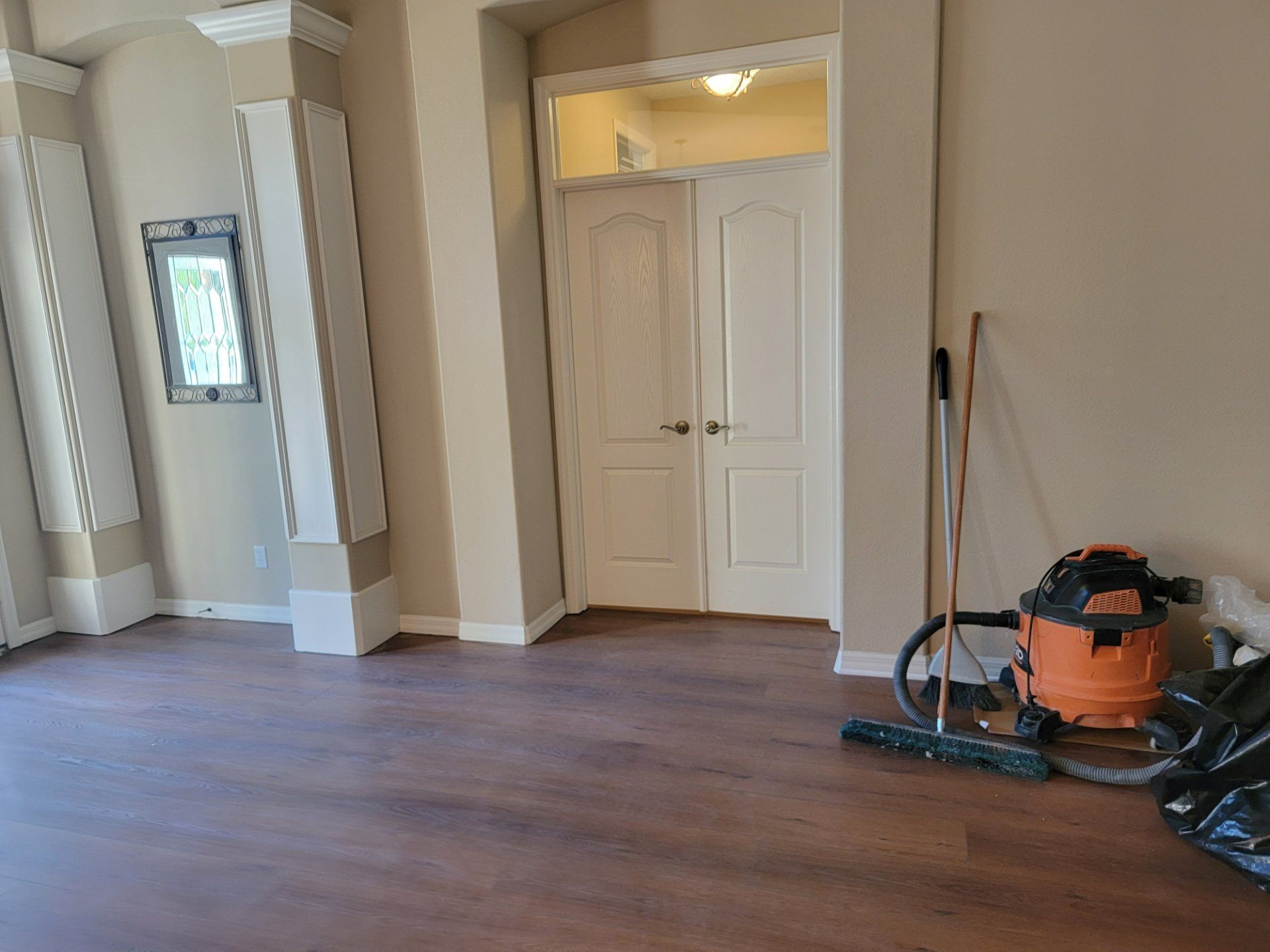 There is a vacuum cleaner and a broom in the room.
