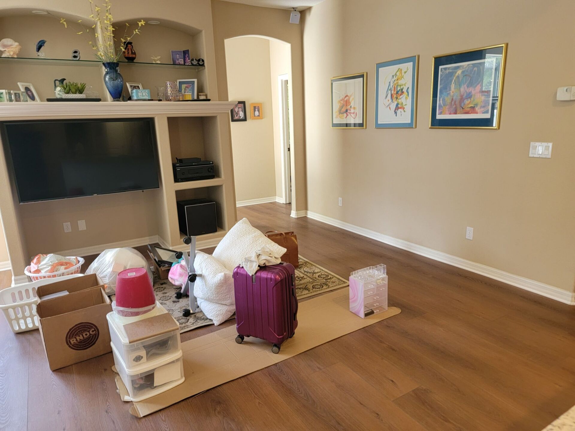 A living room filled with boxes and luggage and a flat screen tv.