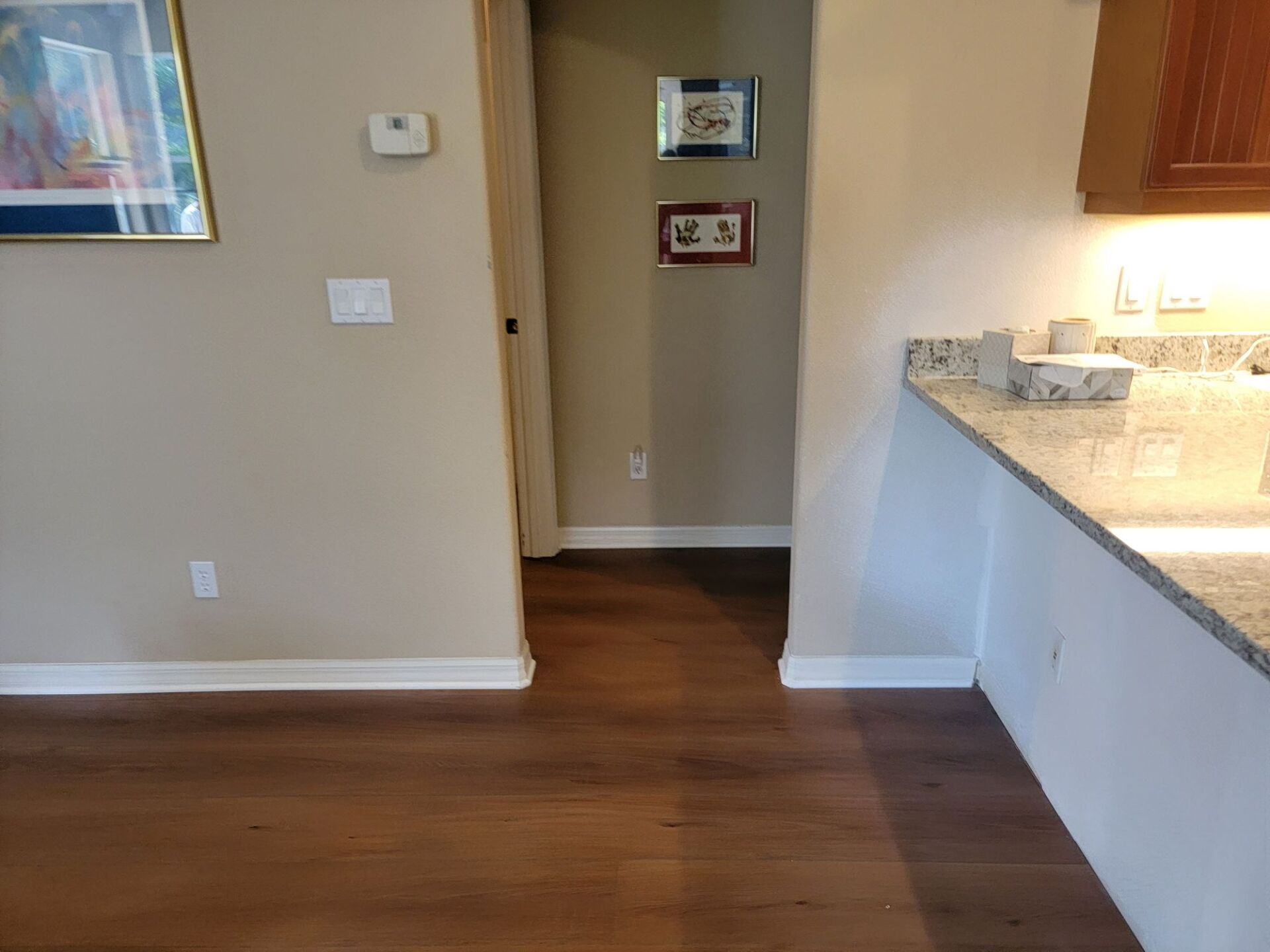 A kitchen with hardwood floors and granite counter tops