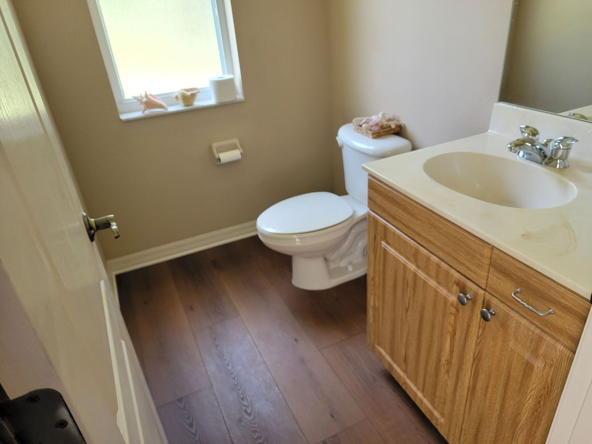 A bathroom with a toilet , sink and mirror.