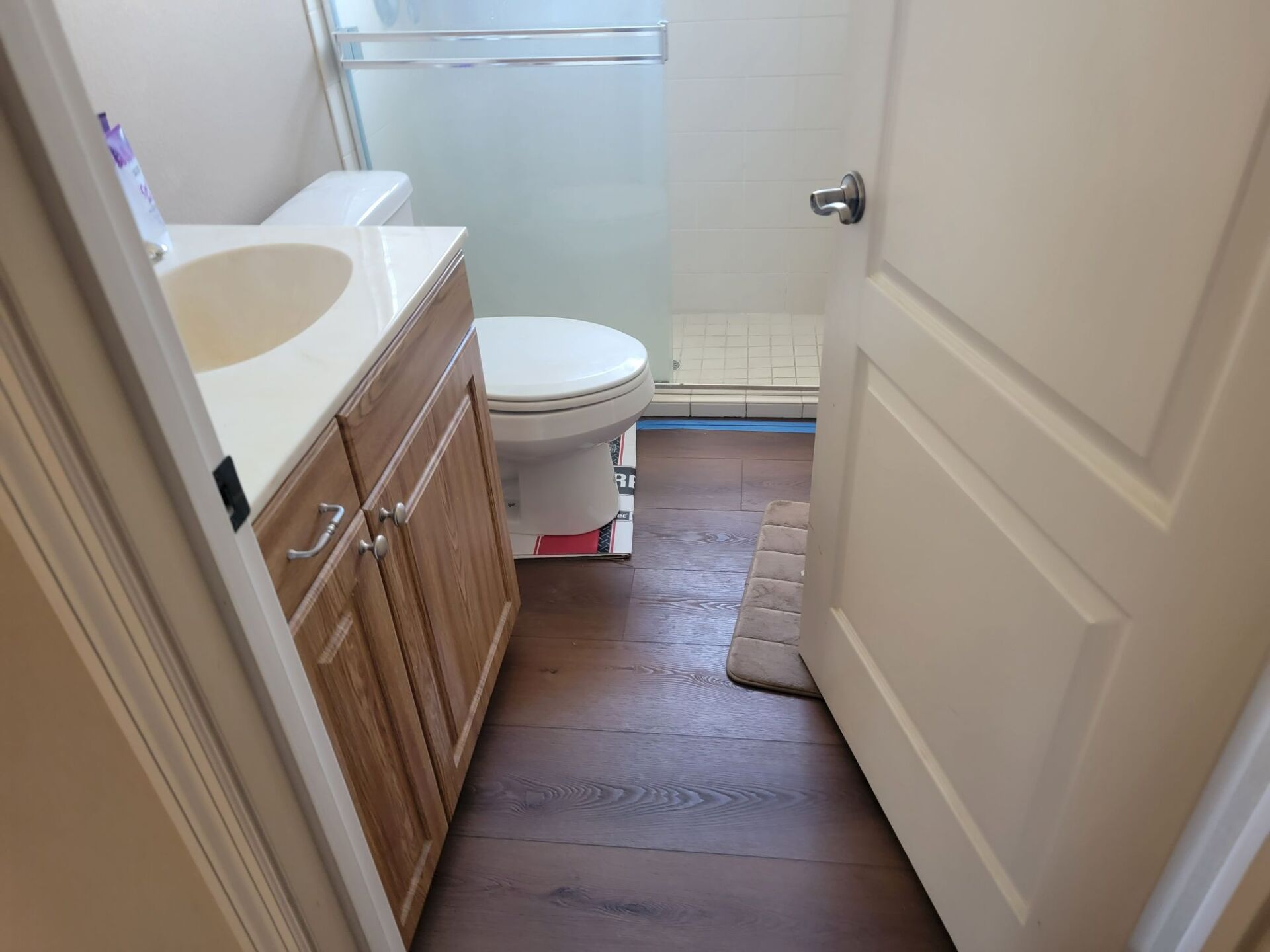 A bathroom with a toilet a sink and a shower