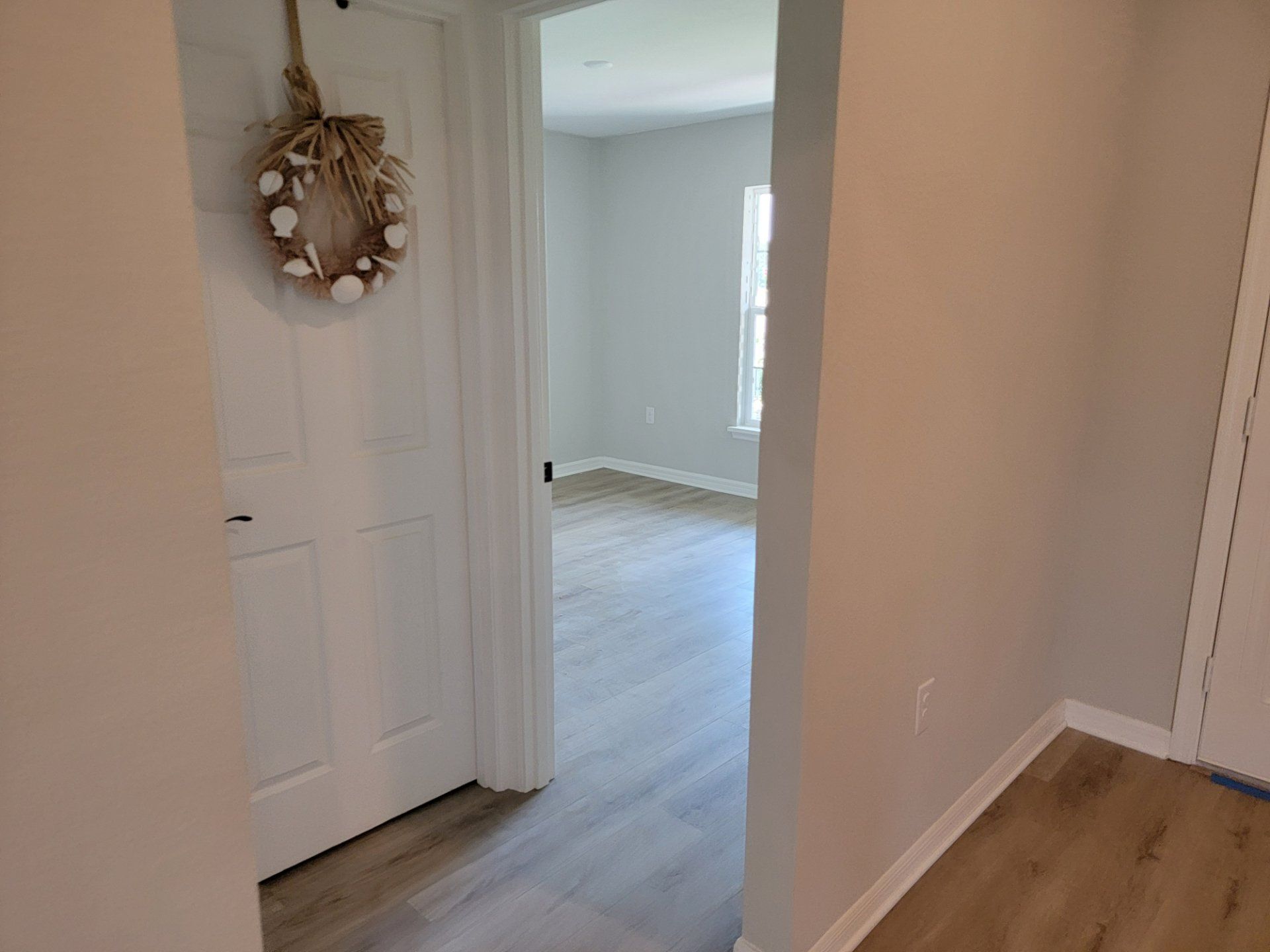 A hallway in a house with a wreath hanging on the door.