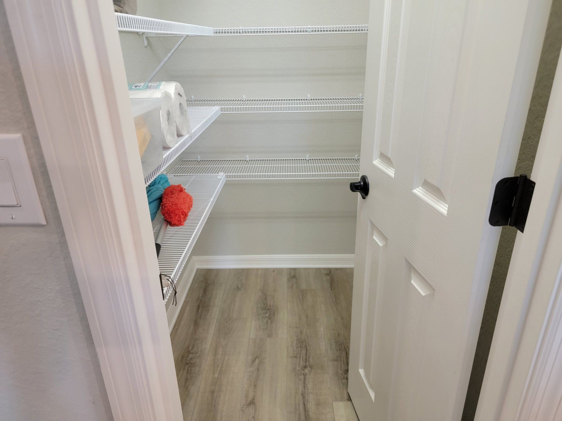 A walk in closet with shelves and a door in a house.