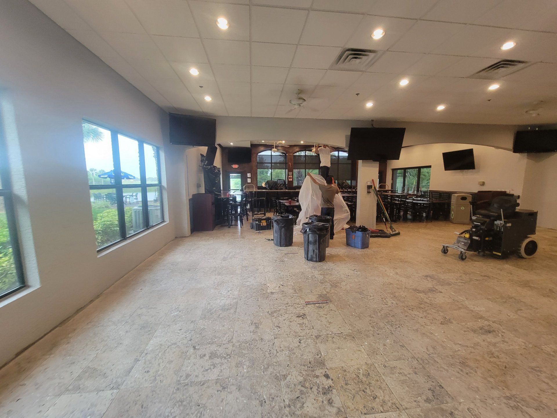 A large room with a lot of windows and a vacuum cleaner in it.