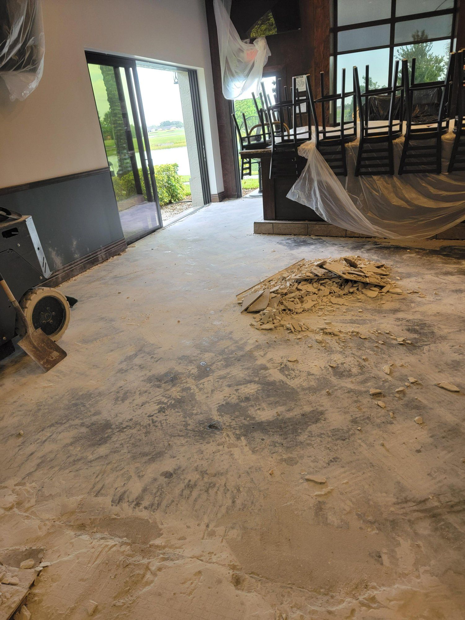 A room with a lot of dirt on the floor and chairs sitting on the floor.