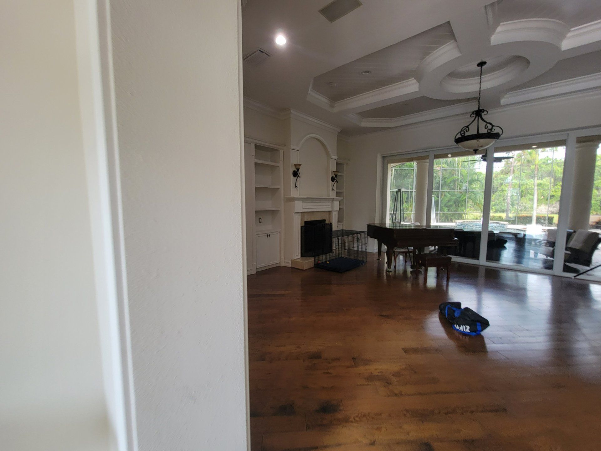 An empty living room with hardwood floors and a fireplace.