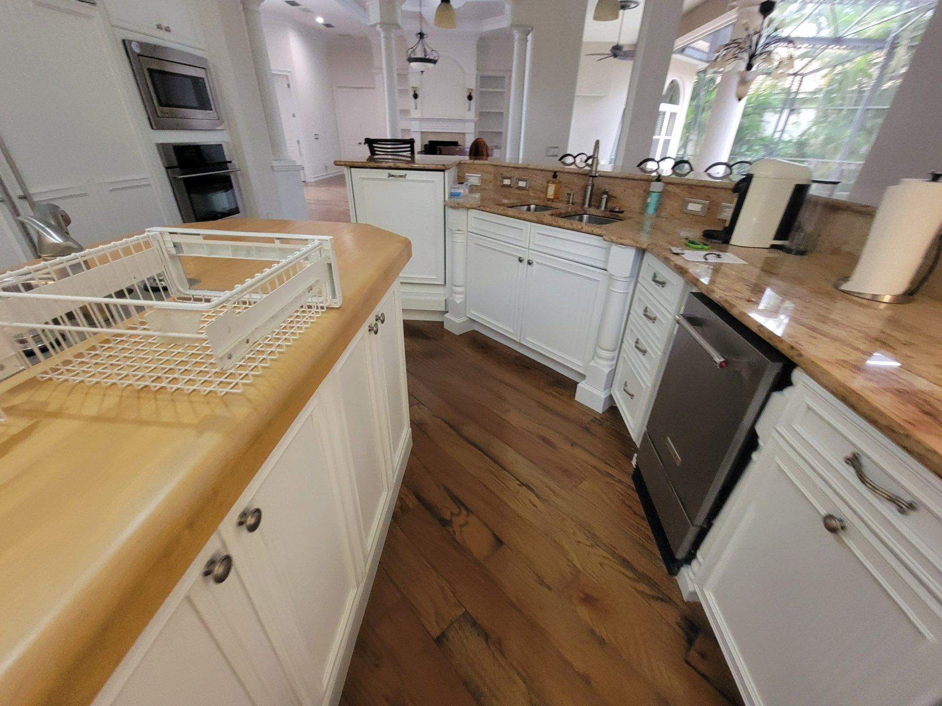 A kitchen with white cabinets and wooden counter tops