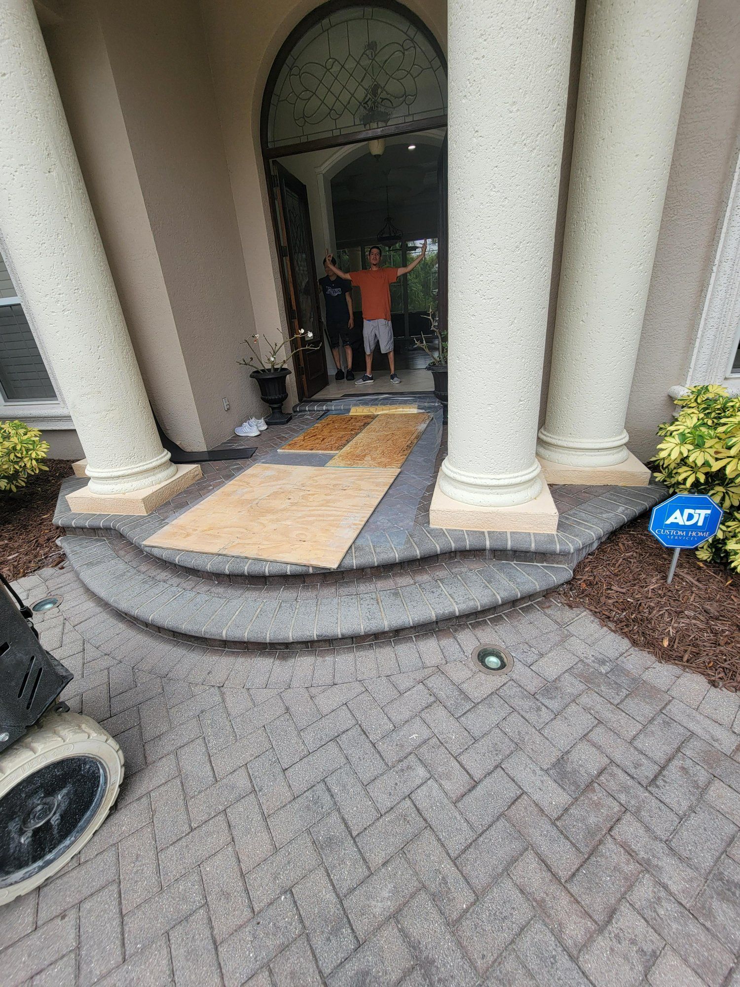 A man in a wheelchair is standing in front of a house.