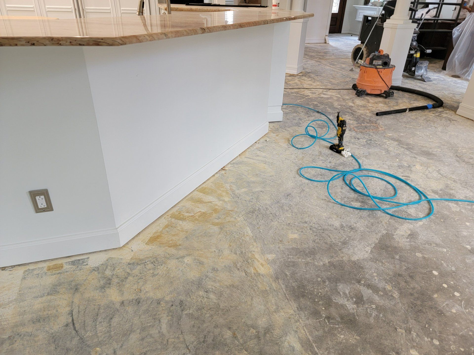 A vacuum cleaner is sitting on the floor in a kitchen.