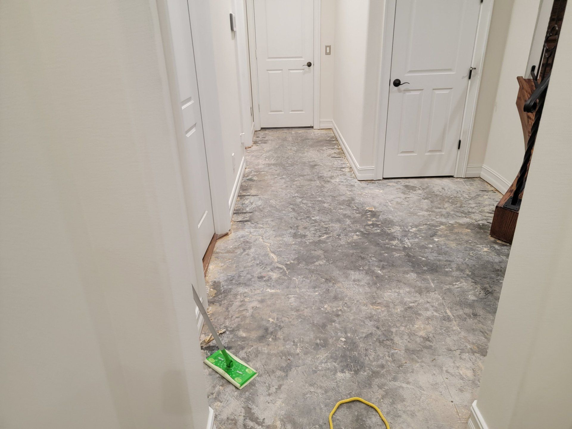 A hallway in a house with a mop on the floor.