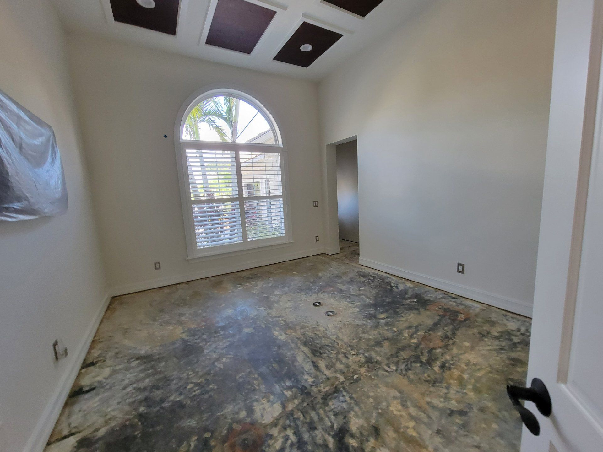 An empty room with a concrete floor and a window.