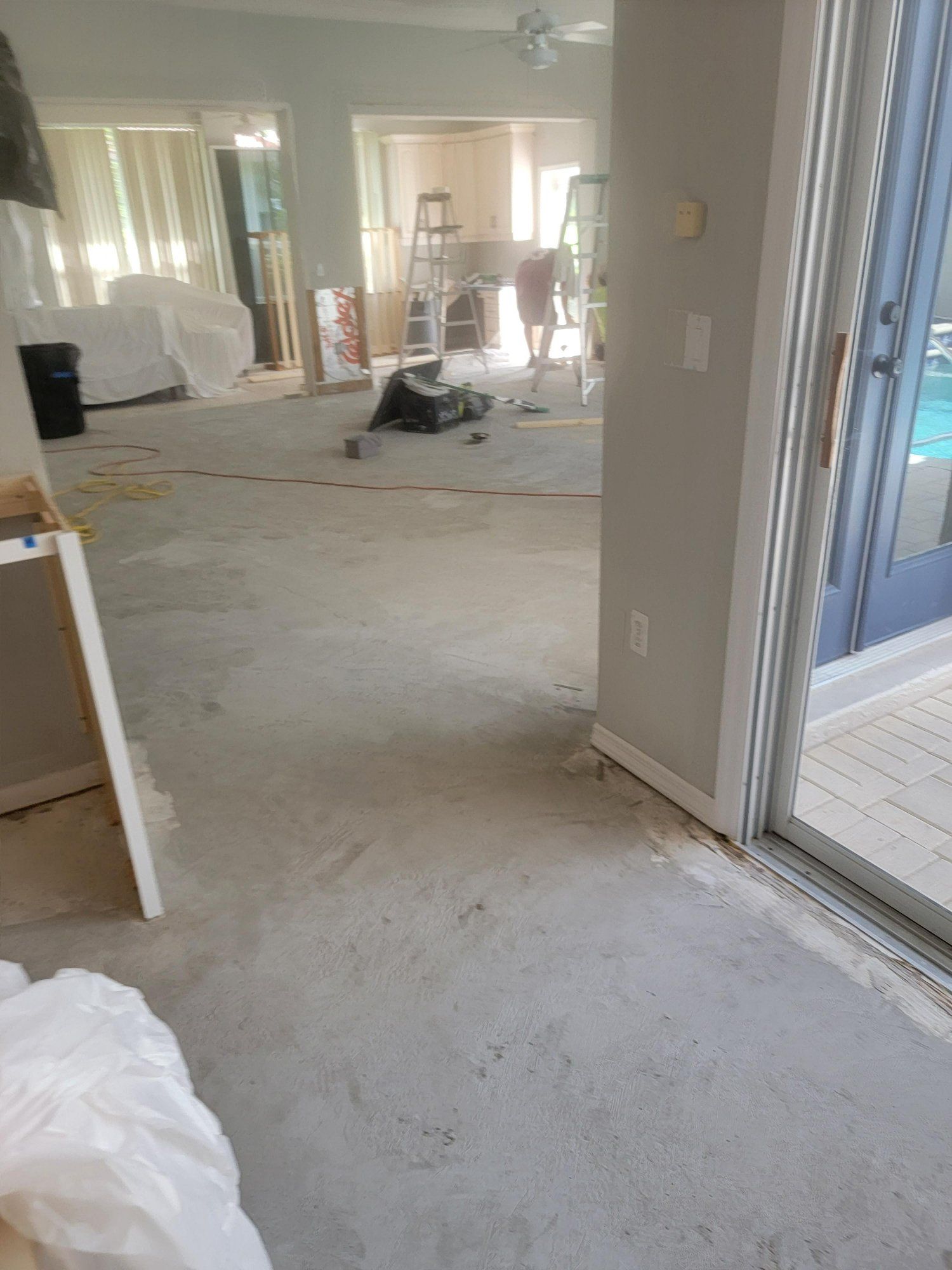 A living room with a sliding glass door and a carpet on the floor.