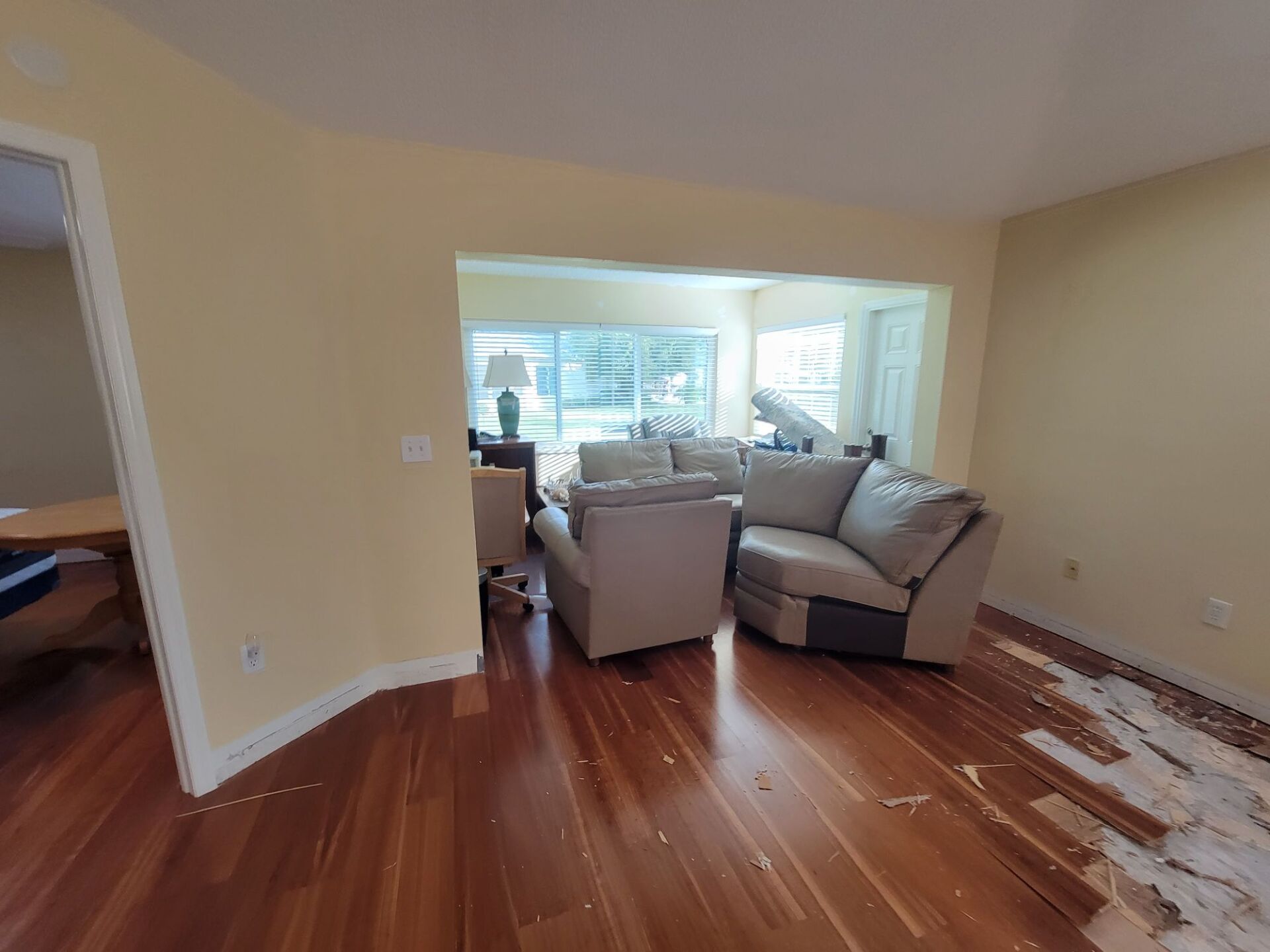 A living room with hardwood floors and a couch and chairs.