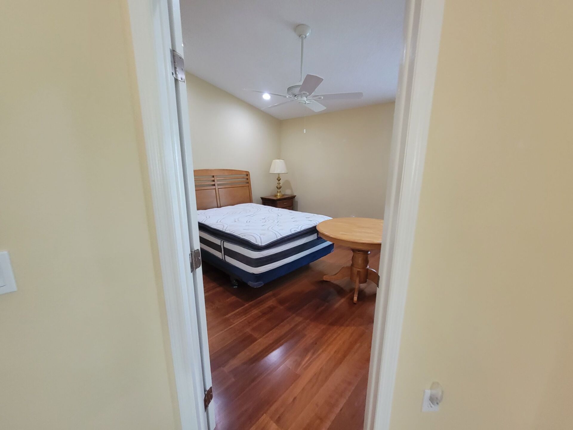 A bedroom with a bed , table and ceiling fan.
