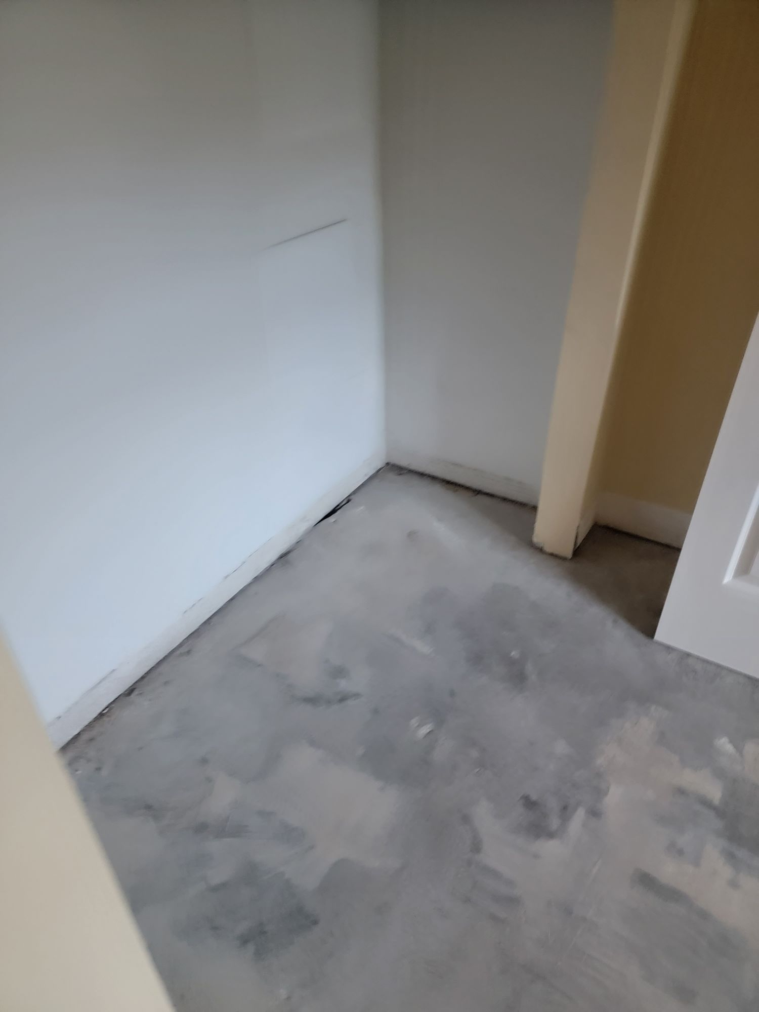 A room with a gray tile floor and white walls