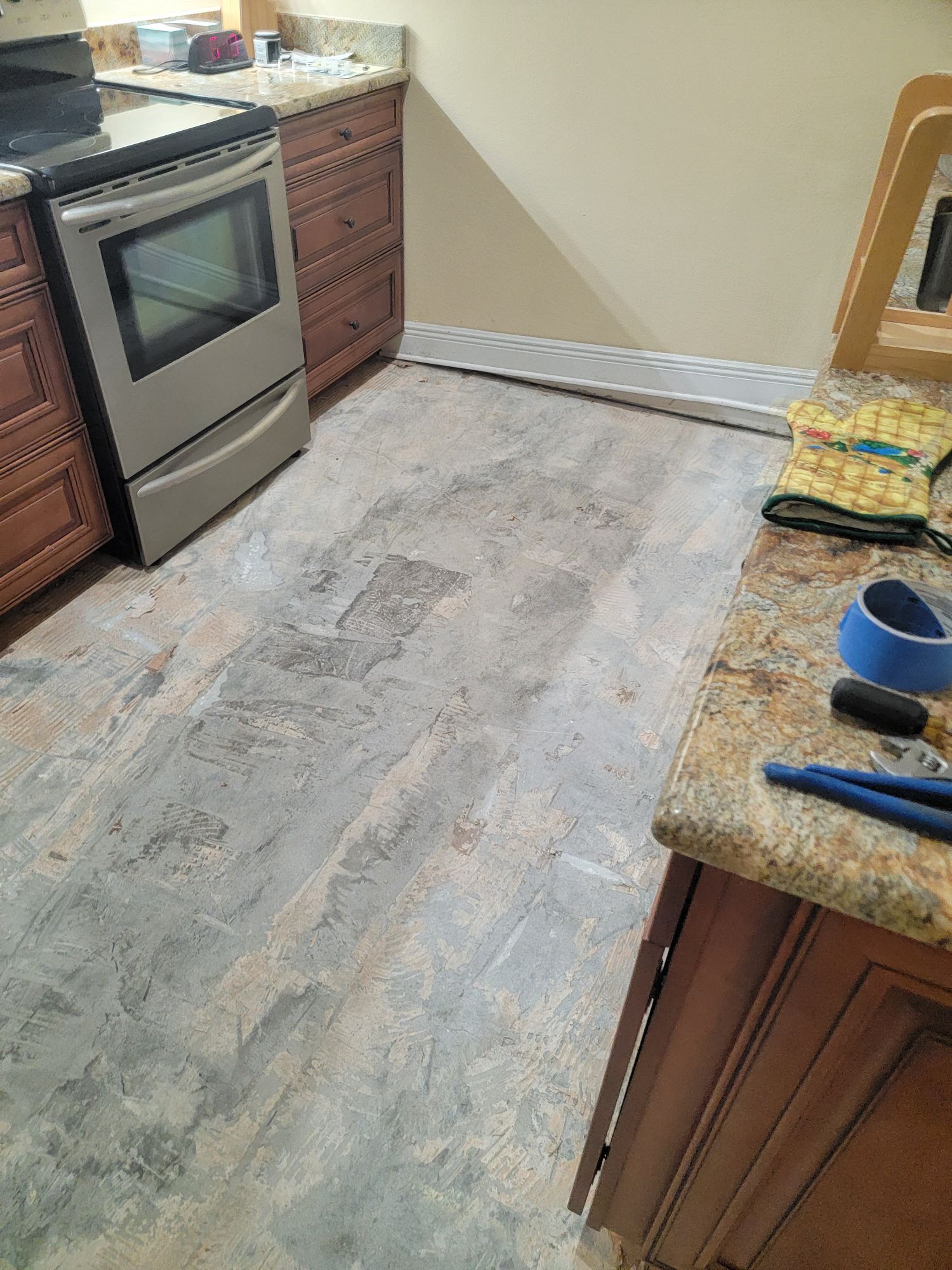A kitchen with a stove , dishwasher , cabinets and a counter top.