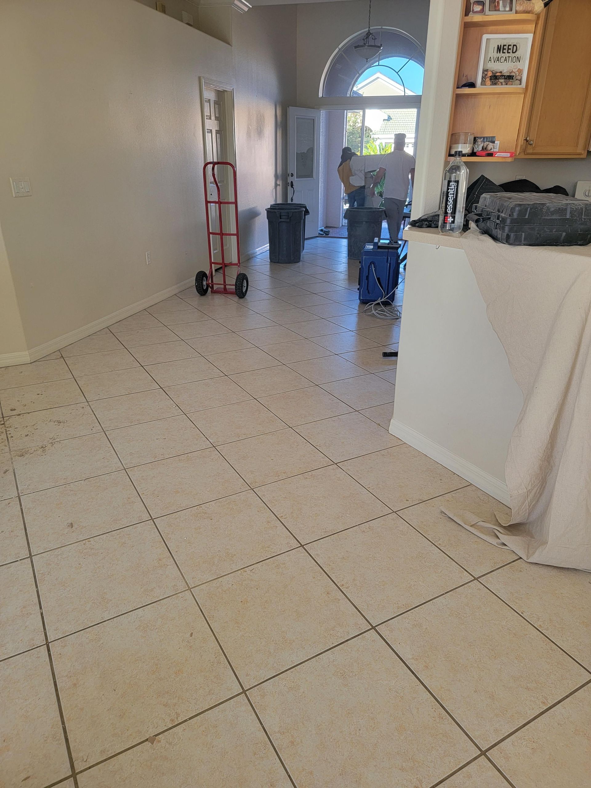 A room with a tiled floor and a red dolly in it.