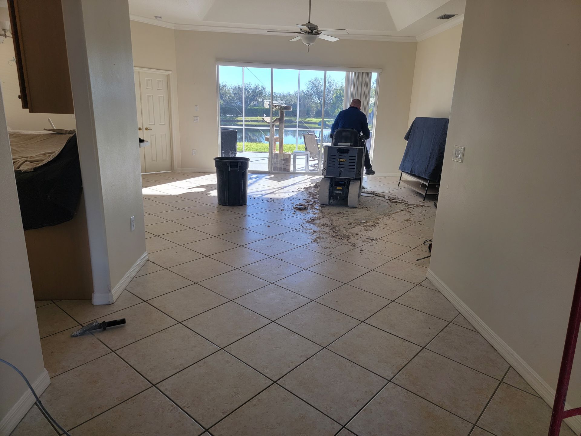A man is standing in a living room with a ceiling fan.
