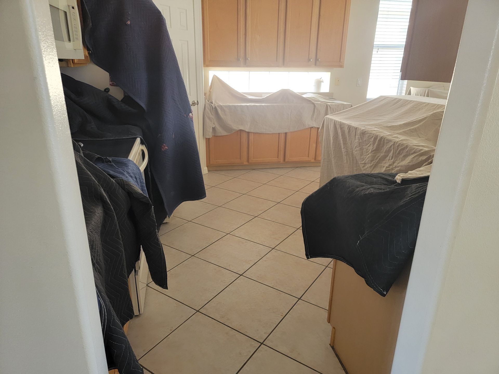 A room with a tiled floor and wooden cabinets