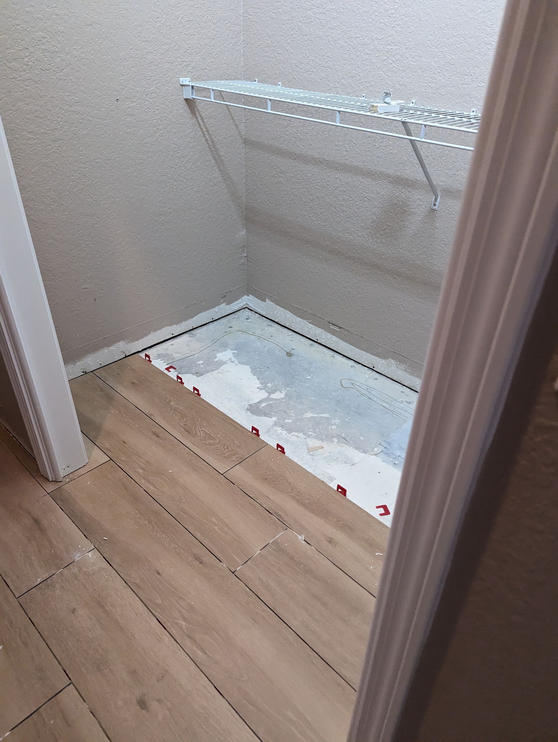 A bathroom with wooden floors and a shower stall.