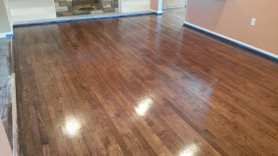 Dark stained hardwood floor with high-gloss finish, reflecting light.