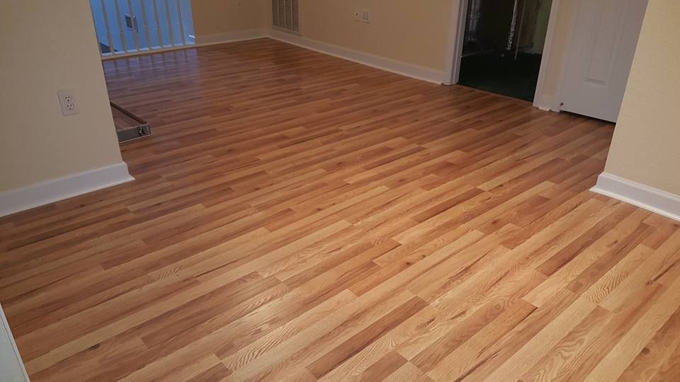 Light hardwood floors in a room, with white trim and beige walls.