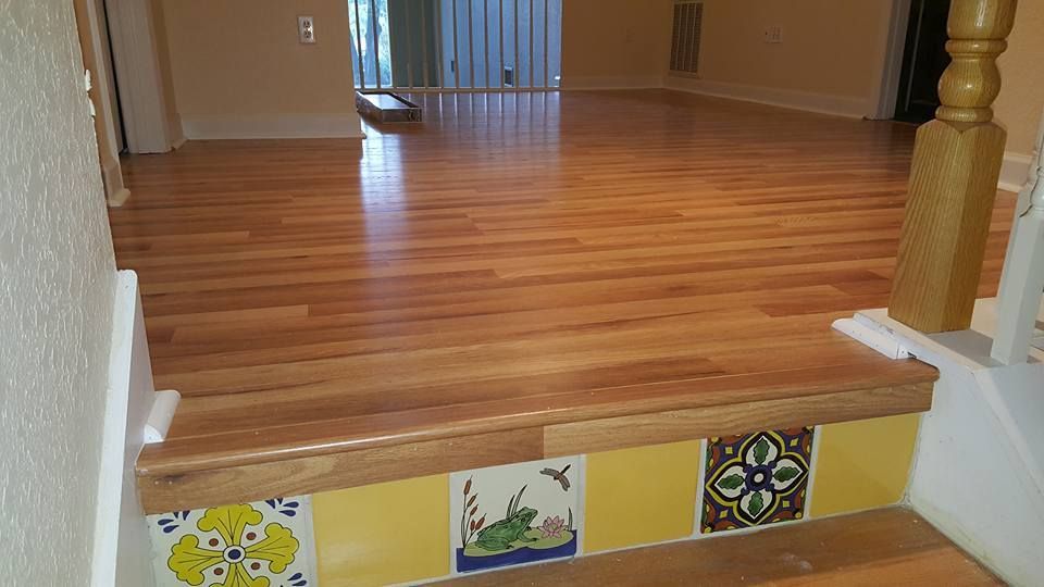 Wooden flooring and steps with decorative yellow tiles.