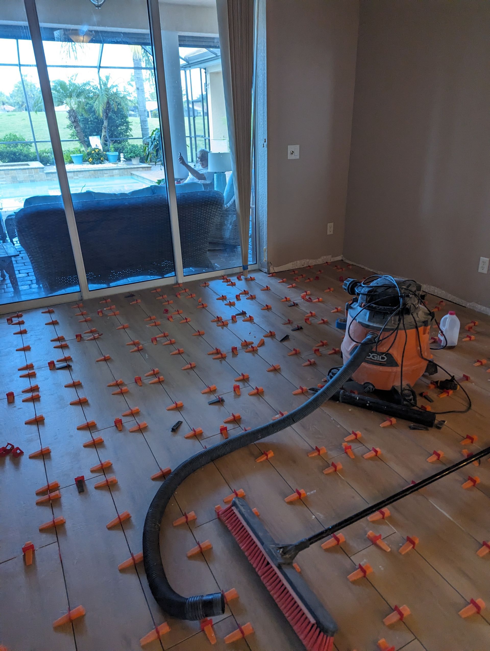 A vacuum cleaner is sitting on a wooden floor in a living room.
