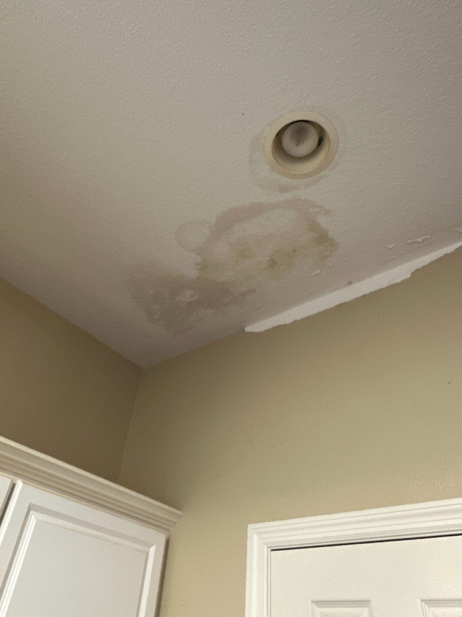 A ceiling with a hole in it and a light on it