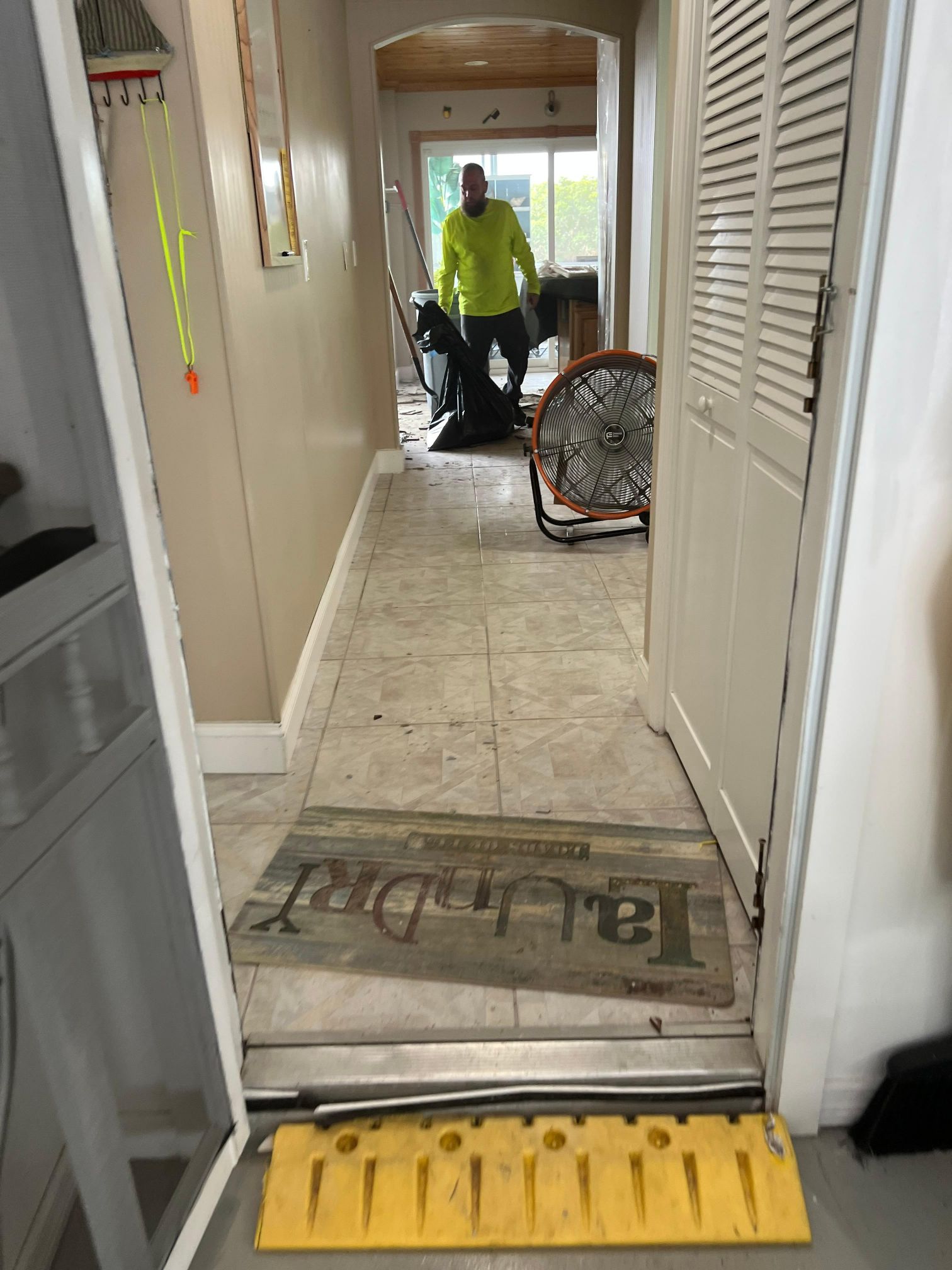 A man is standing in a hallway next to a laundry mat.