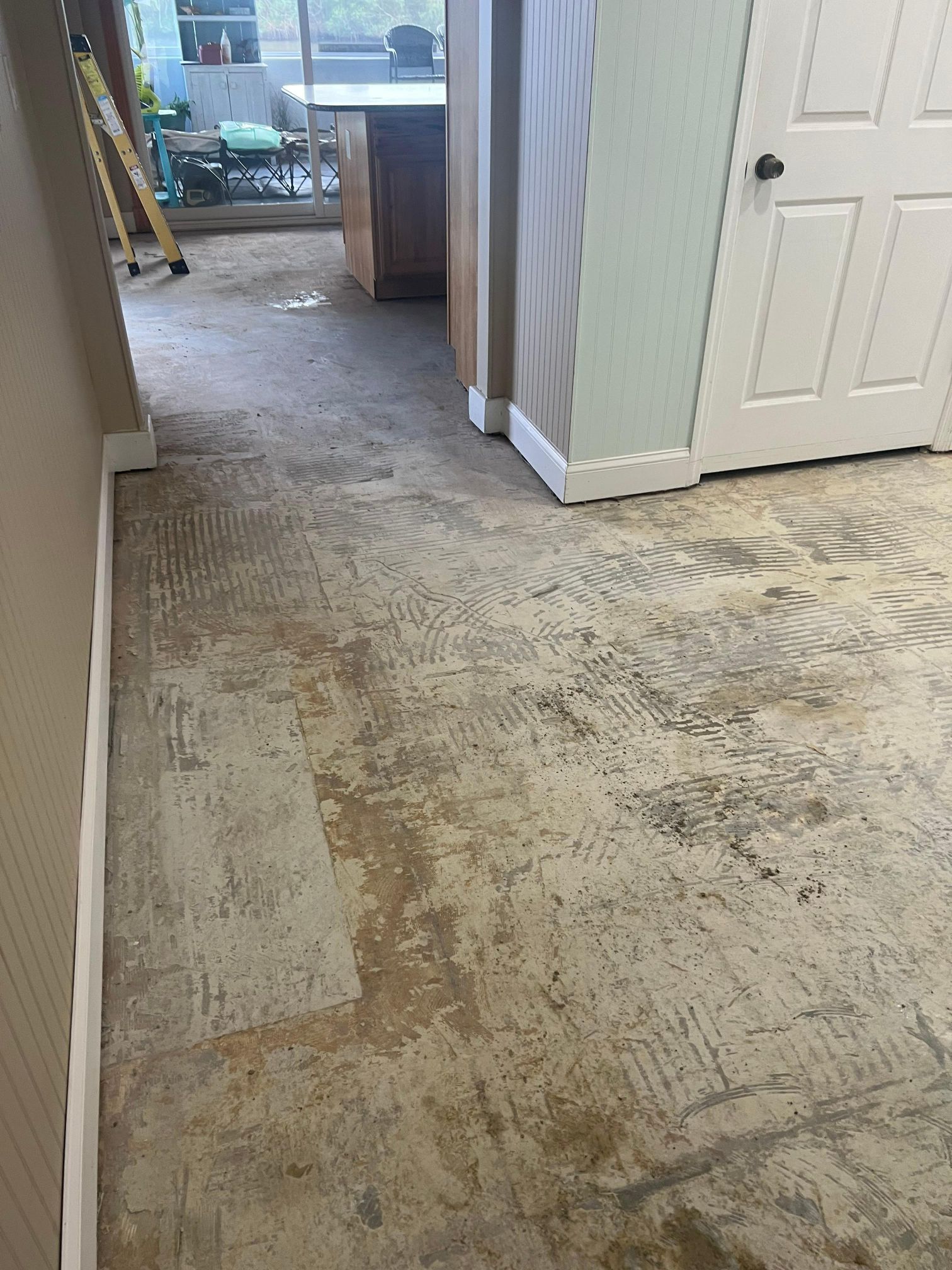 A room with a dirty floor and a door.