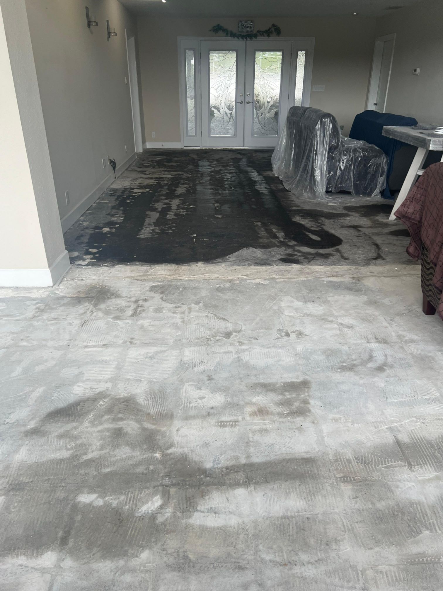 A living room with a concrete floor and a chair in it.