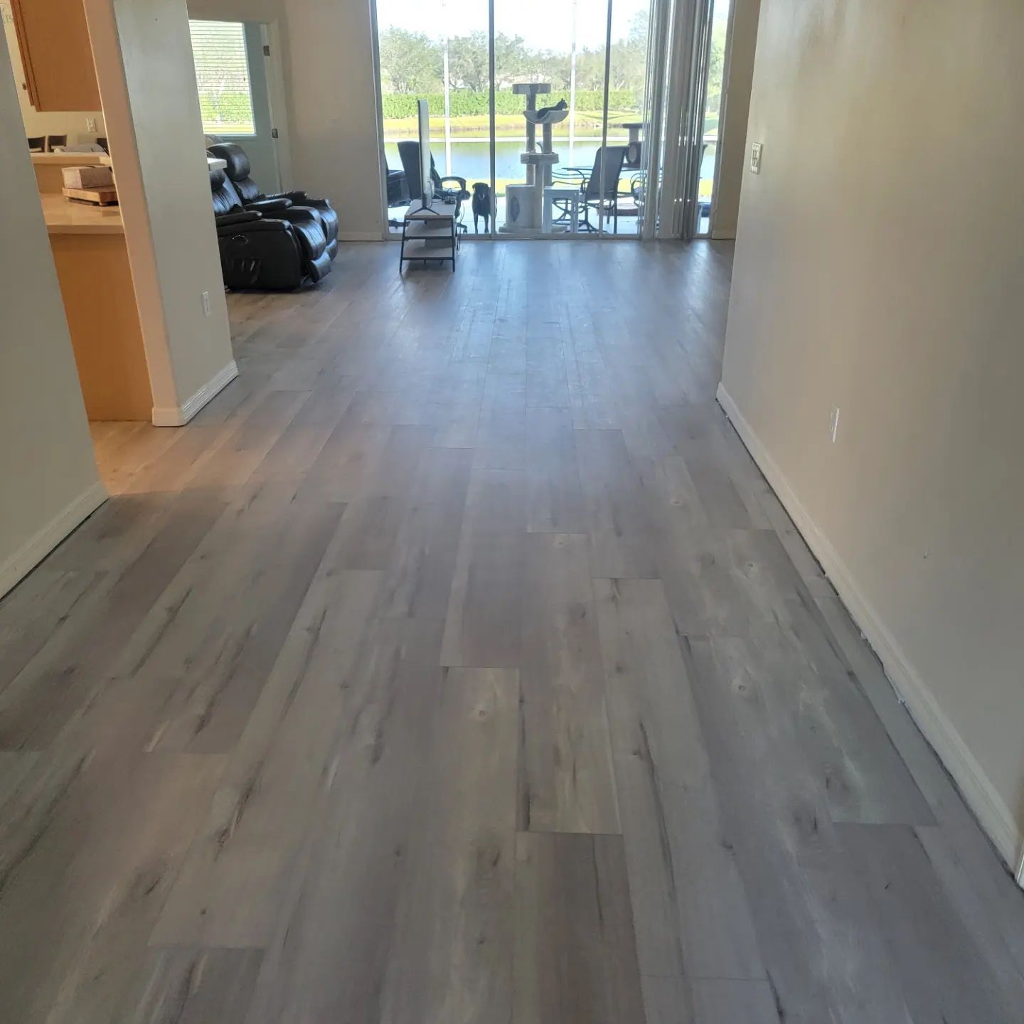 A living room with hardwood floors and a large window.