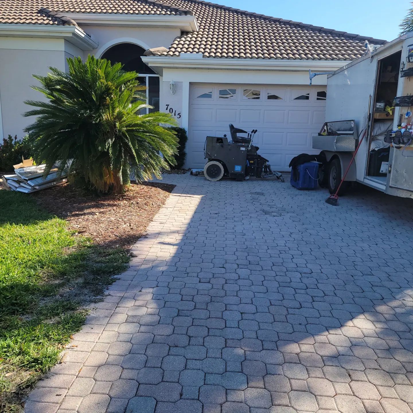 A white truck is parked in front of a white house