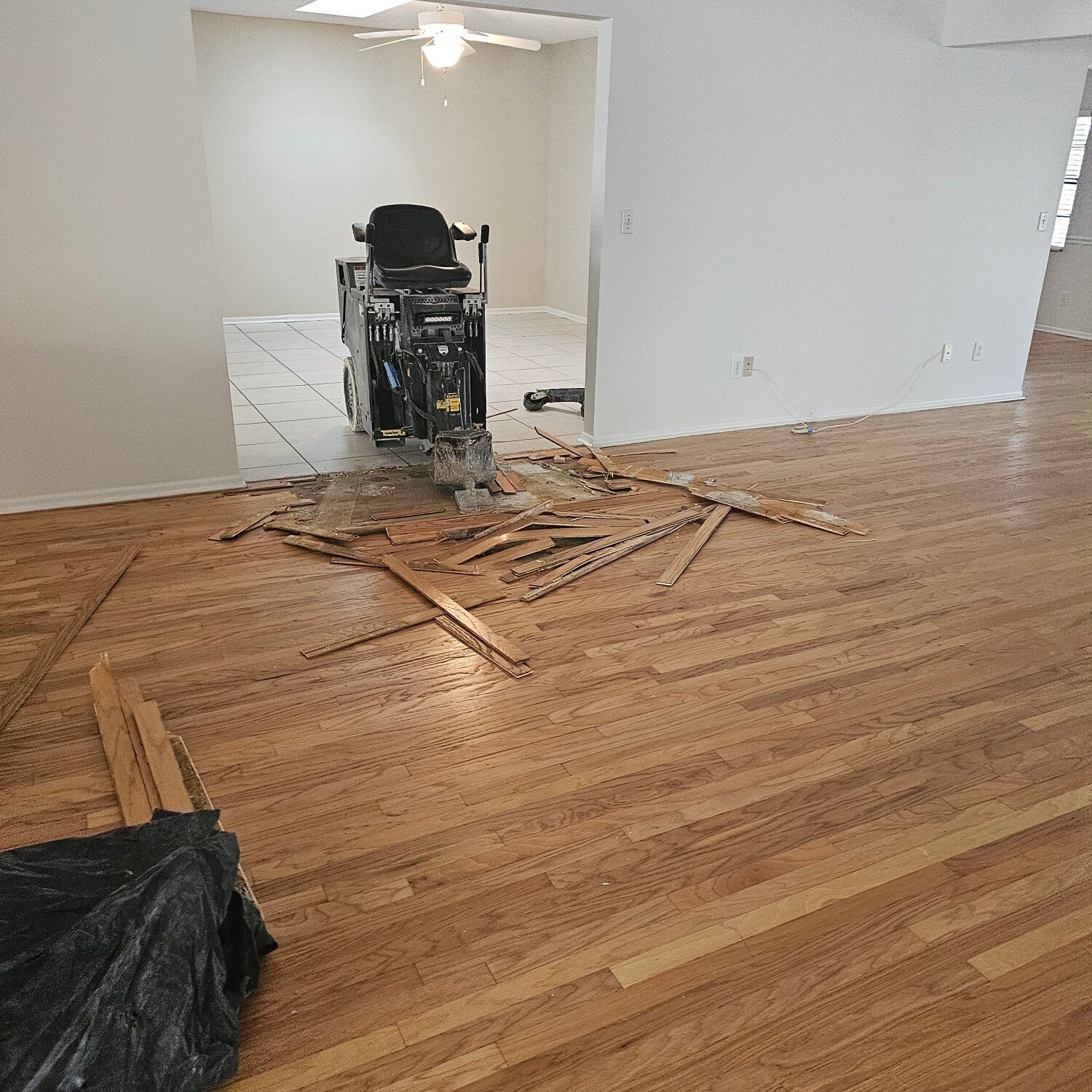 A room with hardwood floors and a machine on the floor.