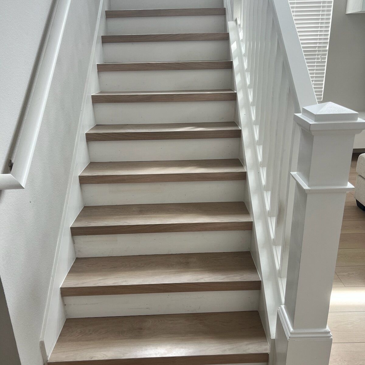 A white staircase with wooden steps and a white railing