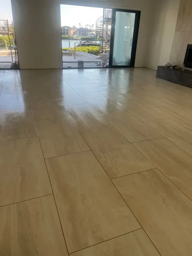 Refinished hardwood floor in a room with light blue walls and a window covered in plastic sheeting.