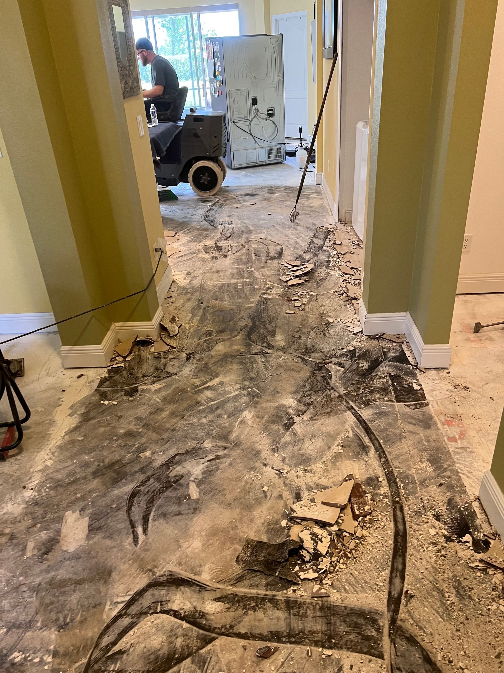 A man is cleaning the floor of a house with a vacuum cleaner.