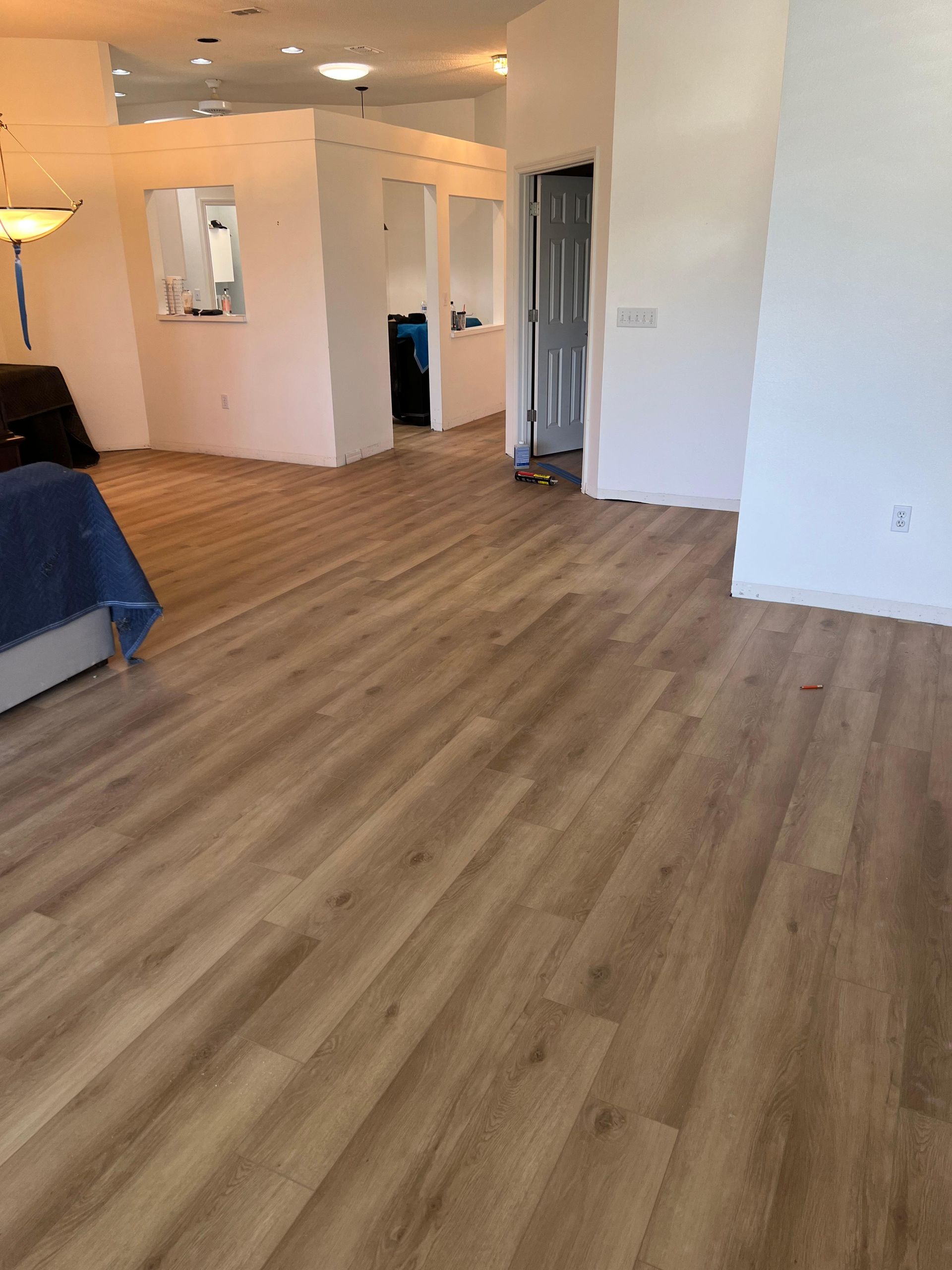 A living room with hardwood floors and white walls.