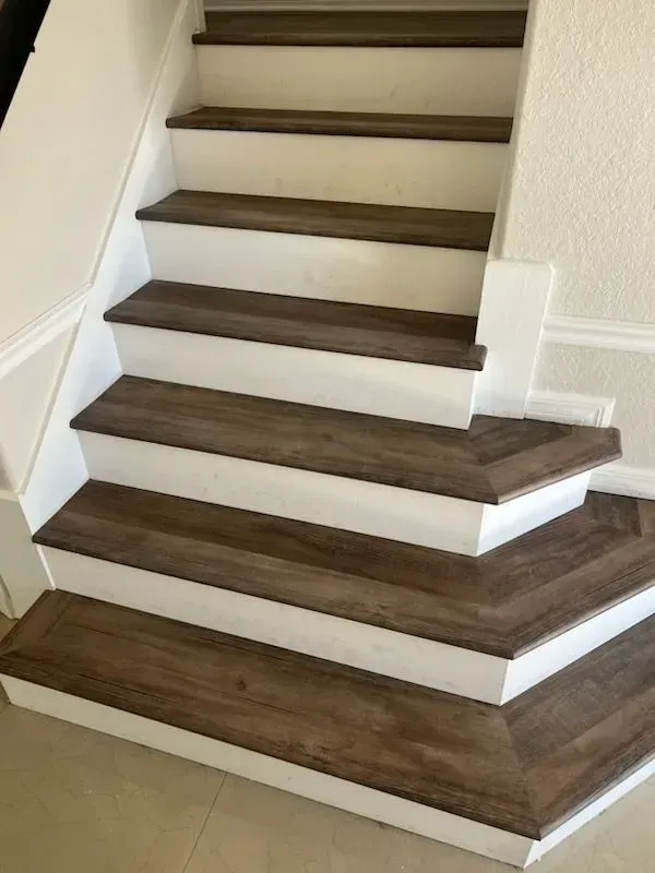 Wooden stair treads with white risers. Interior setting.
