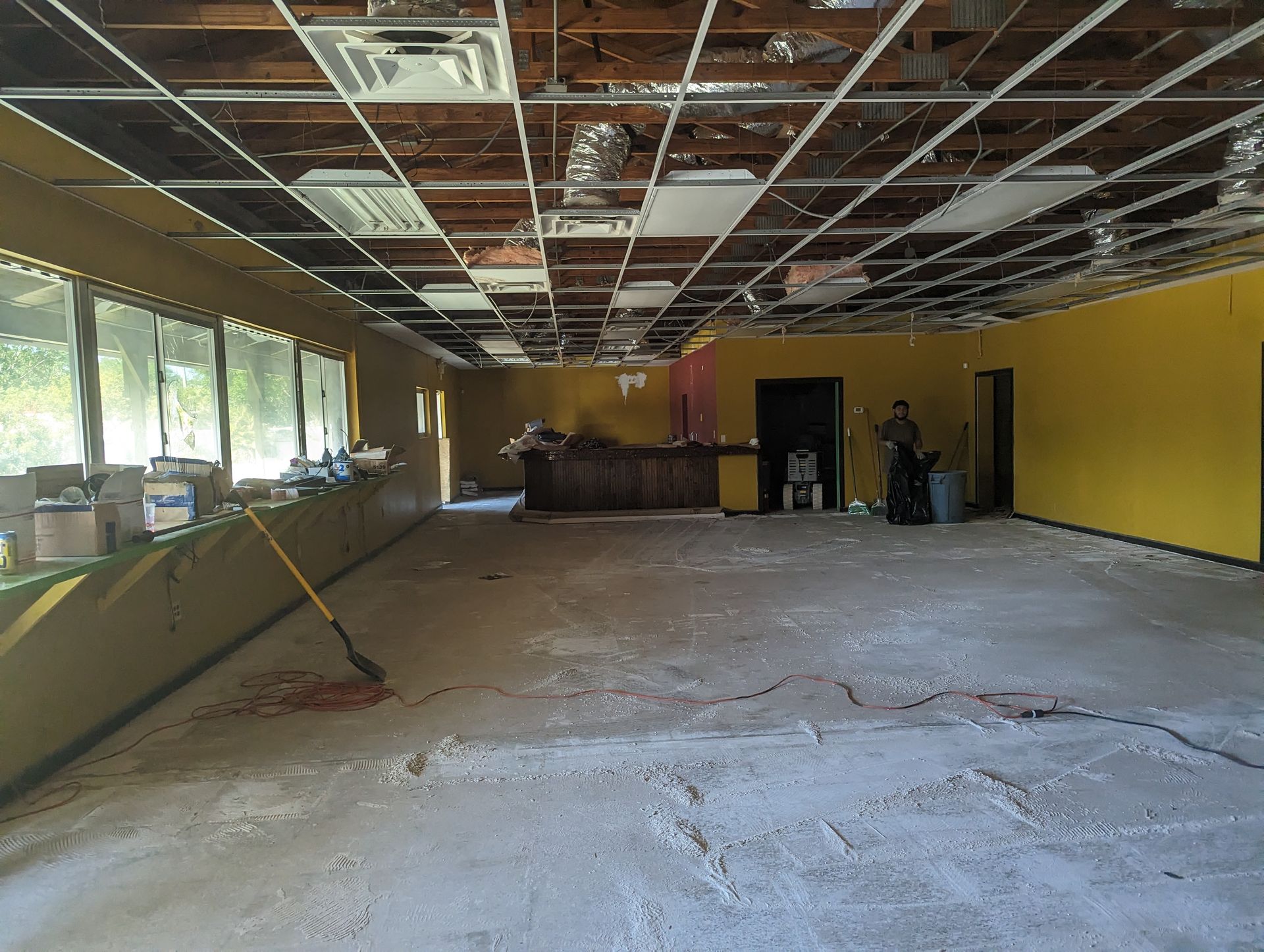 A large empty room with yellow walls and a broom on the floor.